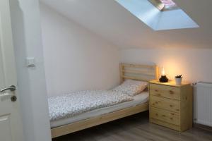 a bedroom with a bed and a dresser and a skylight at Ferienwohnung Stefanko in Bernau