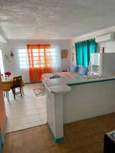 a bedroom with a bed and a kitchen with a table at Orrie's Beach Bar and Hotel in Crab Hill