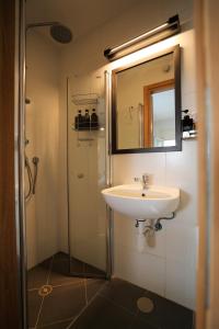 a bathroom with a sink and a shower with a mirror at Jungle in Town - Central Jaffa in Tel Aviv