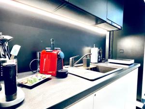 uma cozinha com um aparelho vermelho no balcão em Grandeur em Timisoara