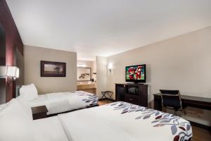 Una habitación de hotel con una cama y un televisor de pantalla plana. en Red Roof Inn Bishopville, en Bishopville 14 fotos más