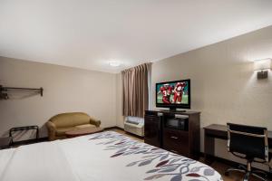 ein Hotelzimmer mit einem Bett und einem Flachbild-TV in der Unterkunft Red Roof Inn Bishopville in Bishopville