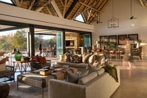 a living room with couches and chairs and tables at Monwana in Thornybush Game Reserve