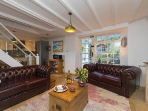 a living room with brown leather couches and a table at St Ives View in St Ives