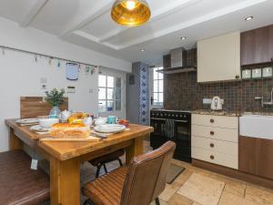 a kitchen with a wooden table and chairs in it at St Ives View in St Ives
