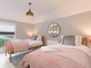 a bedroom with two beds and a mirror at St Ives View in St Ives