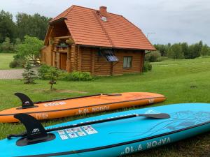 three kayaks are sitting in front of a cabin at Kundziņi in Bīriņi