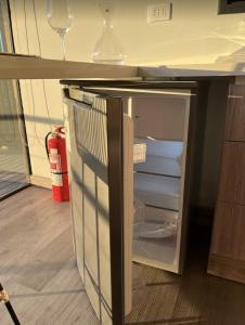 een lege koelkast met de deur open in een keuken bij ALMA Lodge in Matanzas