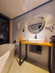 uma casa de banho com um lavatório, um espelho e uma banheira em Pousada Alpes da Araucárias em São Francisco de Paula