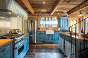 eine Küche mit blauen Schränken und einem Herd in der Unterkunft CHALET NAHÉLÉ in Val-des-Lacs