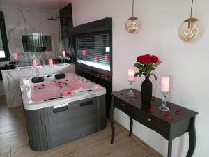 een badkamer met een jacuzzi en een tafel met kaarsen bij Préstige in Rouilly-Sacey