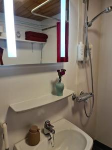 a white bathroom with a sink and a mirror at Cozy cottage in quiet location in Oulu