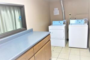 a laundry room with a sink and a washer and dryer at Super 8 by Wyndham Burlington in Burlington
