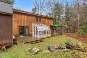 a house with a greenhouse in front of it at Stratton Woods in West Wardsboro