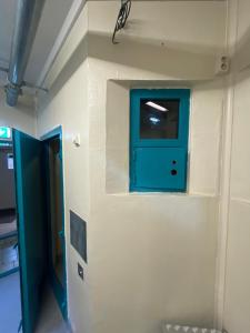 Cette chambre est dotée d'une porte bleue sur le mur. dans l'établissement Fengselshotellet, à Arendal