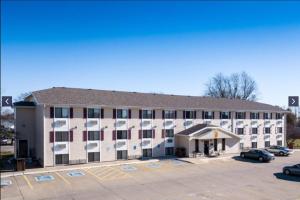 a large building with a parking lot in front of it at Super 8 by Wyndham Burlington in Burlington