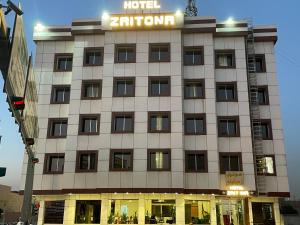 un bâtiment zantium avec un panneau sur celui-ci dans l'établissement Hotel Zaitona, à Erbil