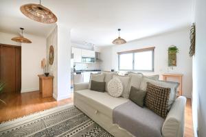 a living room with a couch and a kitchen at Apartment with Private Terrace & Car Garage in Lisbon