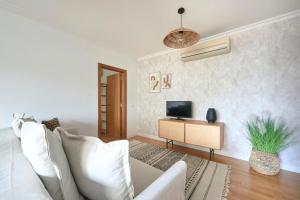 sala de estar con sofá blanco y TV en Apartment with Private Terrace & Car Garage, en Lisboa