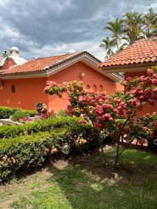 uma casa com flores cor-de-rosa e arbustos à sua frente em Hotel Villas Ajijic, Ajijic Chapala Jalisco em Ajijic