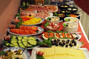 un buffet de diferentes tipos de comida en una mesa en Fair Hotel Villa Diana en Frankfurt