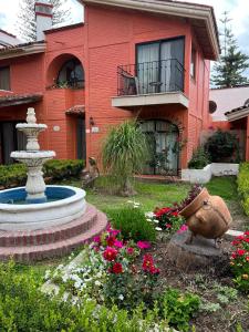 una casa con un jardín con una fuente y flores en Hotel Villas Ajijic, Ajijic Chapala Jalisco en Ajijic