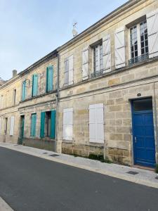 un ancien bâtiment en briques avec des portes et des fenêtres bleues dans l'établissement Le Bourbon, à Bordeaux