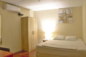 a bedroom with a white bed and a cabinet at Casa Central de Santa Ana in Santa Ana