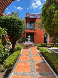 un jardín con una fuente frente a un edificio rojo en Hotel Villas Ajijic, Ajijic Chapala Jalisco en Ajijic