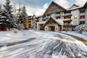 a snow covered street in front of a building at Aspens by WB Vacation Rentals in Whistler