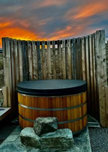 a wooden barrel with rocks in front of a fence at Lexi's Lodge in Lake Tekapo