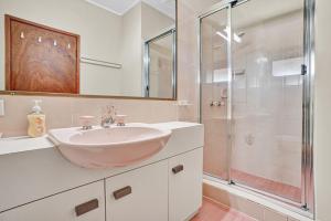 a bathroom with a sink and a glass shower at 41 Carlo Circle Rainbow Beach in Rainbow Beach +24 photos