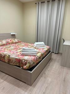 - une chambre avec un lit et des serviettes dans l'établissement Appartamento tra le montagne, à Pescocostanzo