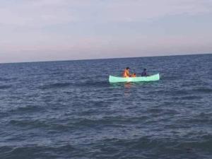 two people in a boat in the ocean at Bancudo Cabin and Resort in Karasanan