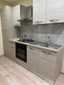 a kitchen with a sink and a stove top oven at Appartamento tra le montagne in Pescocostanzo