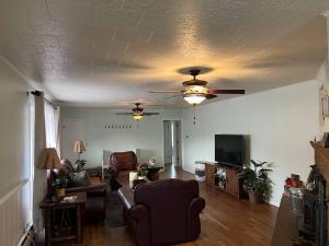 a living room with a ceiling fan and a couch at 2min from rt66 hot tub bocceball court firepit in Williams