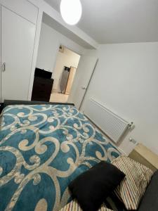 sypialnia z łóżkiem z niebiesko-białym kocem w obiekcie 1 Bed Stunning Central London Apartment City Road w Londynie