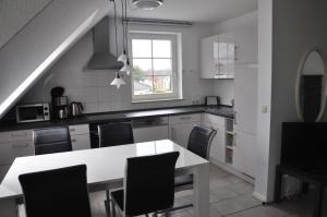 オストゼーバート・カールスハーゲンにあるFewo Peeneblick_LINAのキッチン(白いテーブル、黒い椅子付)