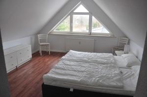 sypialnia z łóżkiem i dużym oknem w obiekcie Fewo Peeneblick_LINA w mieście Karlshagen
