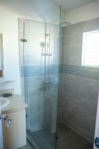 Un baño con ducha de cristal con lavabo. en TWO KING BEDS NEAR PUERTO SECO BEACH, en Discovery Bay 19 fotos más