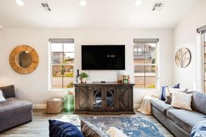 a living room with a couch and a tv on a wall at Zion Sunrise townhouse in Washington