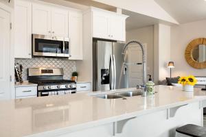 a kitchen with white cabinets and a stainless steel refrigerator at Zion Sunrise townhouse in Washington