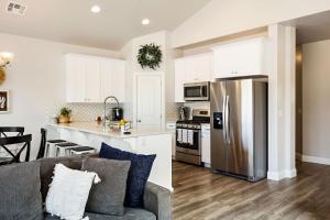 a kitchen and living room with white cabinets and a gray couch at Zion Sunrise townhouse in Washington
