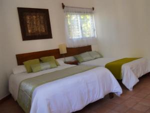 a bedroom with two beds and a window at Los Caracoles Bed & Breakfast in Cancún