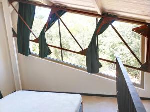 Schlafzimmer mit einem Bett und einem Fenster mit Vorhängen in der Unterkunft Spa Nimeslodge in Nîmes