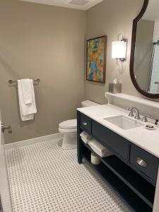 a bathroom with a sink and a toilet and a mirror at The Shepherd Hotel Downtown Clemson in Clemson