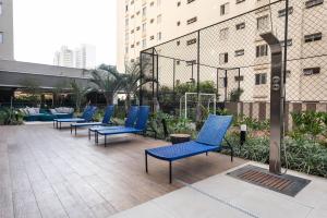 a row of blue chairs sitting on a patio at OA12 Aconchego próximo ao Parque Augusta in Sao Paulo