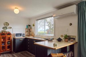 a kitchen with a sink and a window at Miners Cottage lancefield in Lance Field