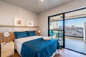 um quarto com uma cama e uma grande janela em VO13 - Apto Luxuoso e Aconchegante no Bom Retiro: Conforto em São Paulo