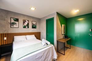 1 dormitorio con cama y pared verde en MV13 - Studio Próximo à Estação Brás: Conforto Garantido, en São Paulo